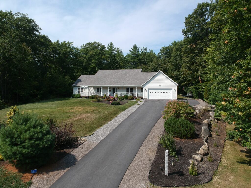 Exterior of a modern farmhouse on a hill surrounded with trees